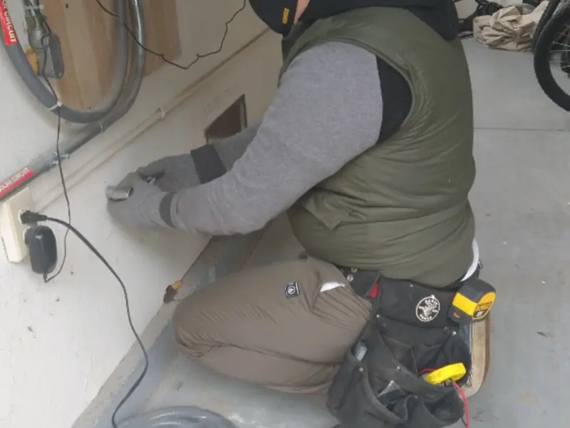 Electrician performing outlet wiring in a Elsa garage